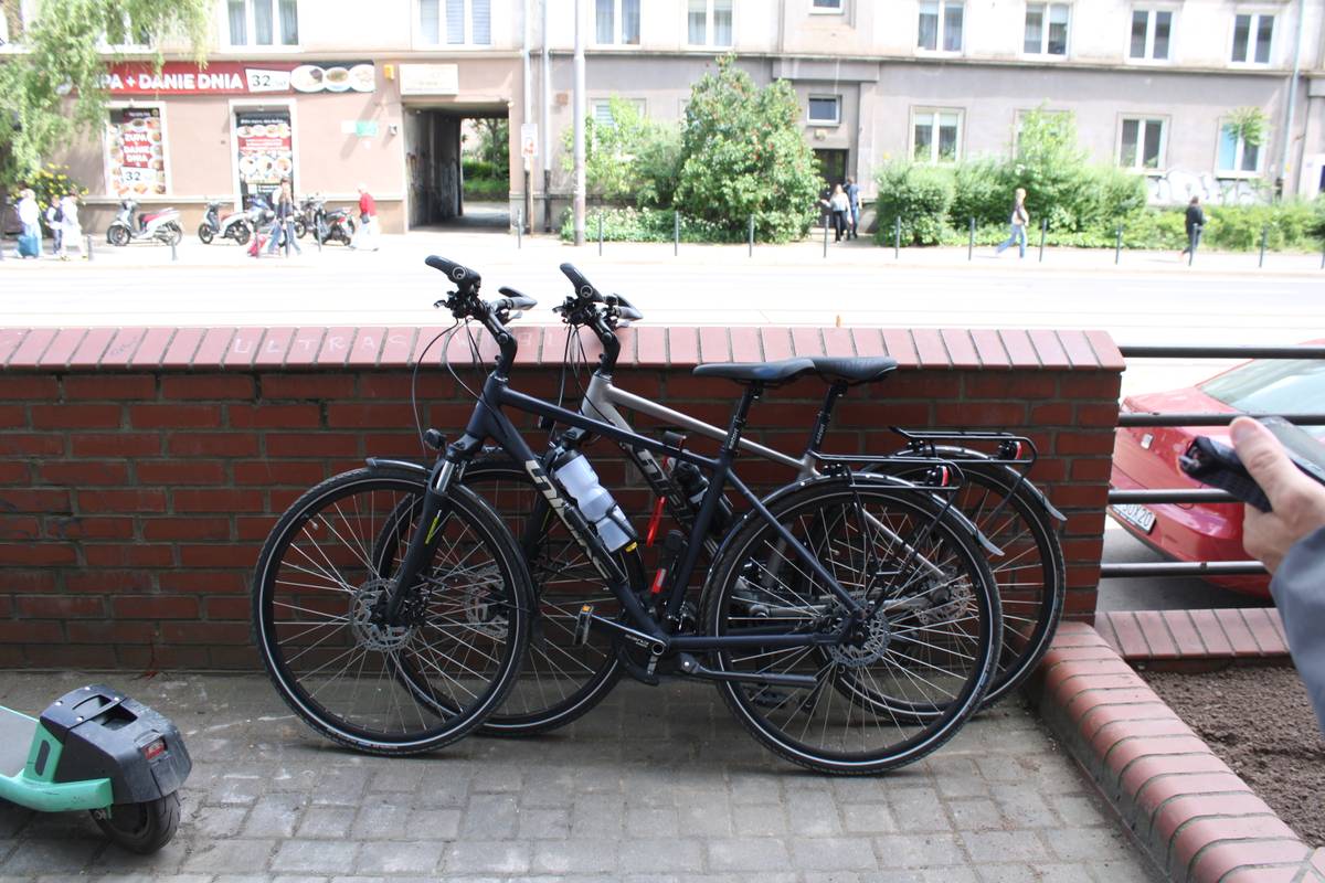 Two bicycles leaned against a stone barrier