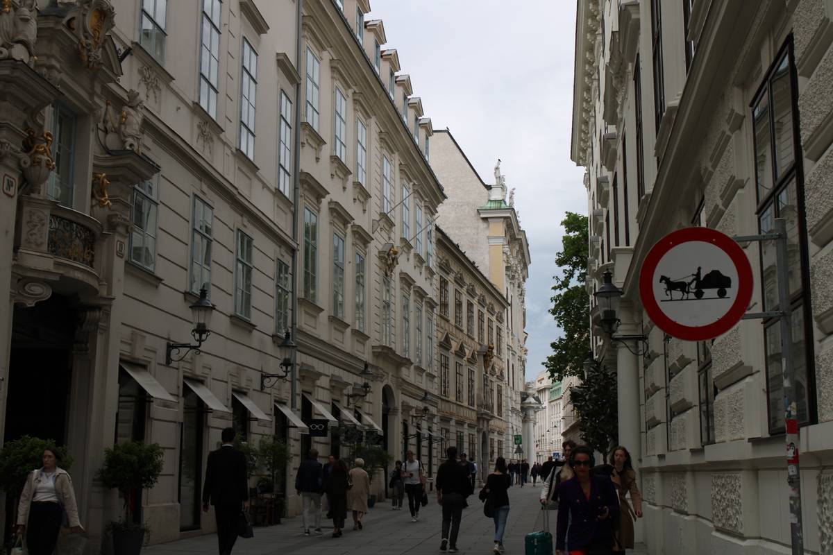 A beige street with a "no horse-drawn carriages" sign.