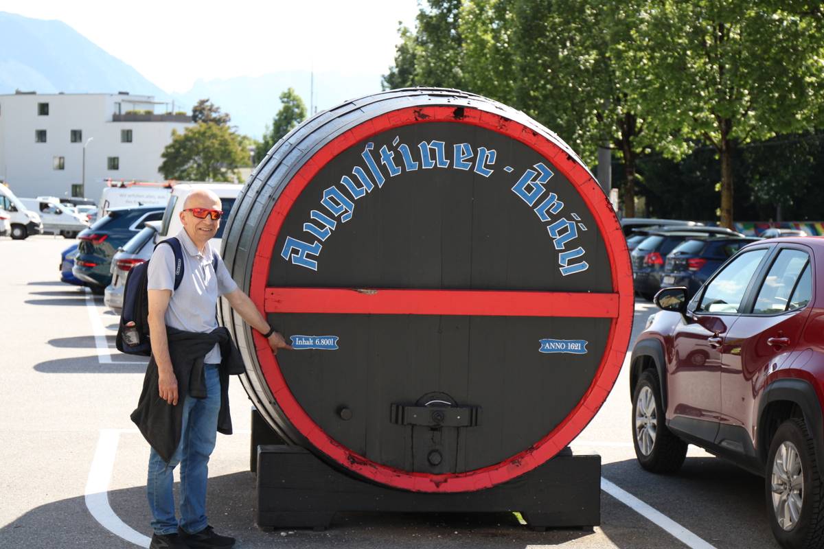 My dad stands pointing a giant barrel of beer
