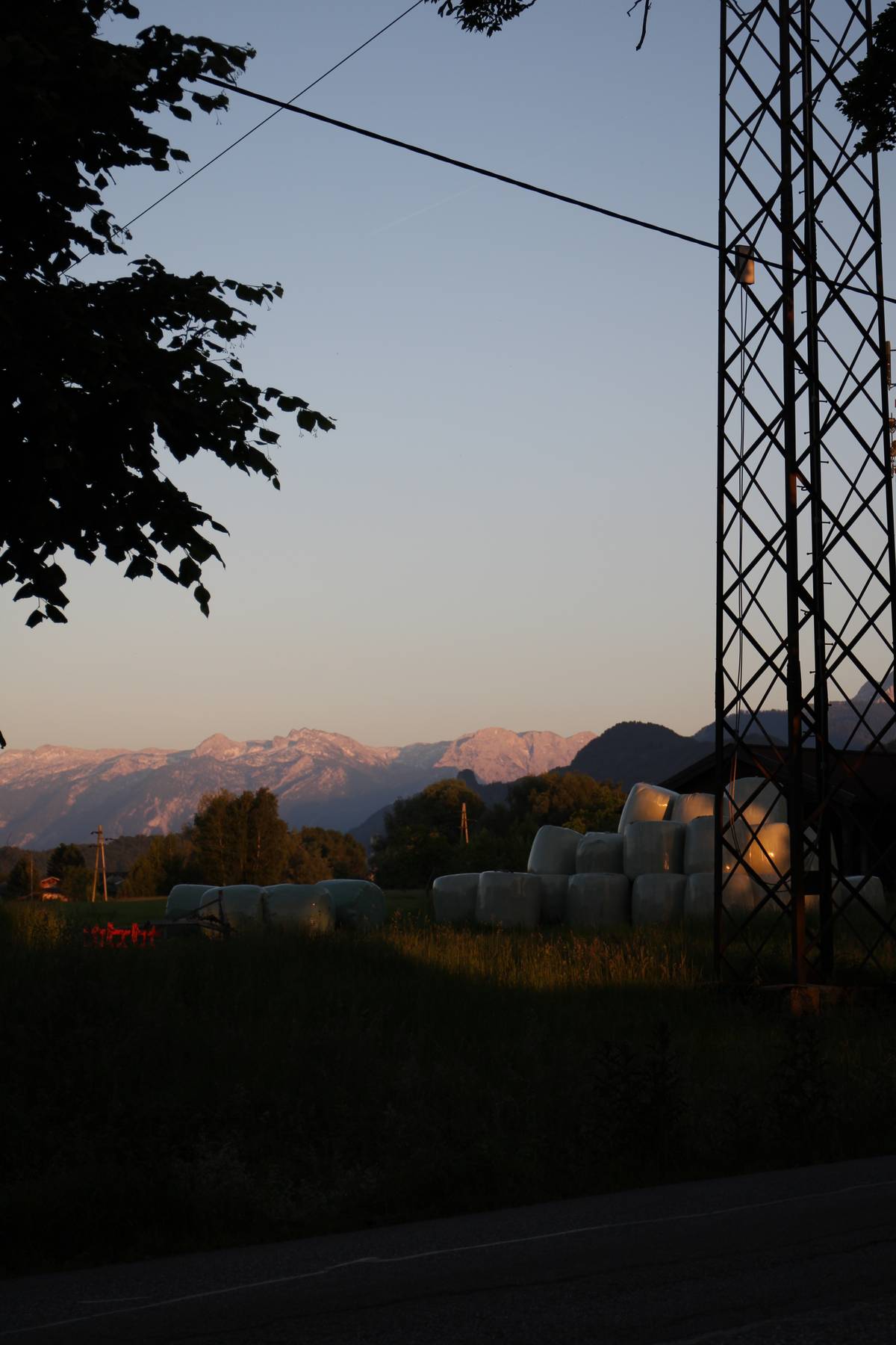 A view of a field with some wrapped hay