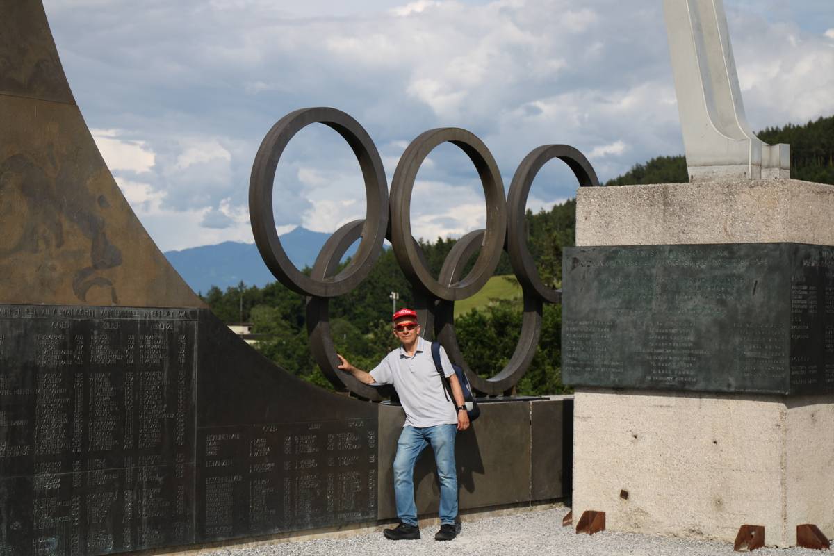 My dad poses by the olympic rings and torch