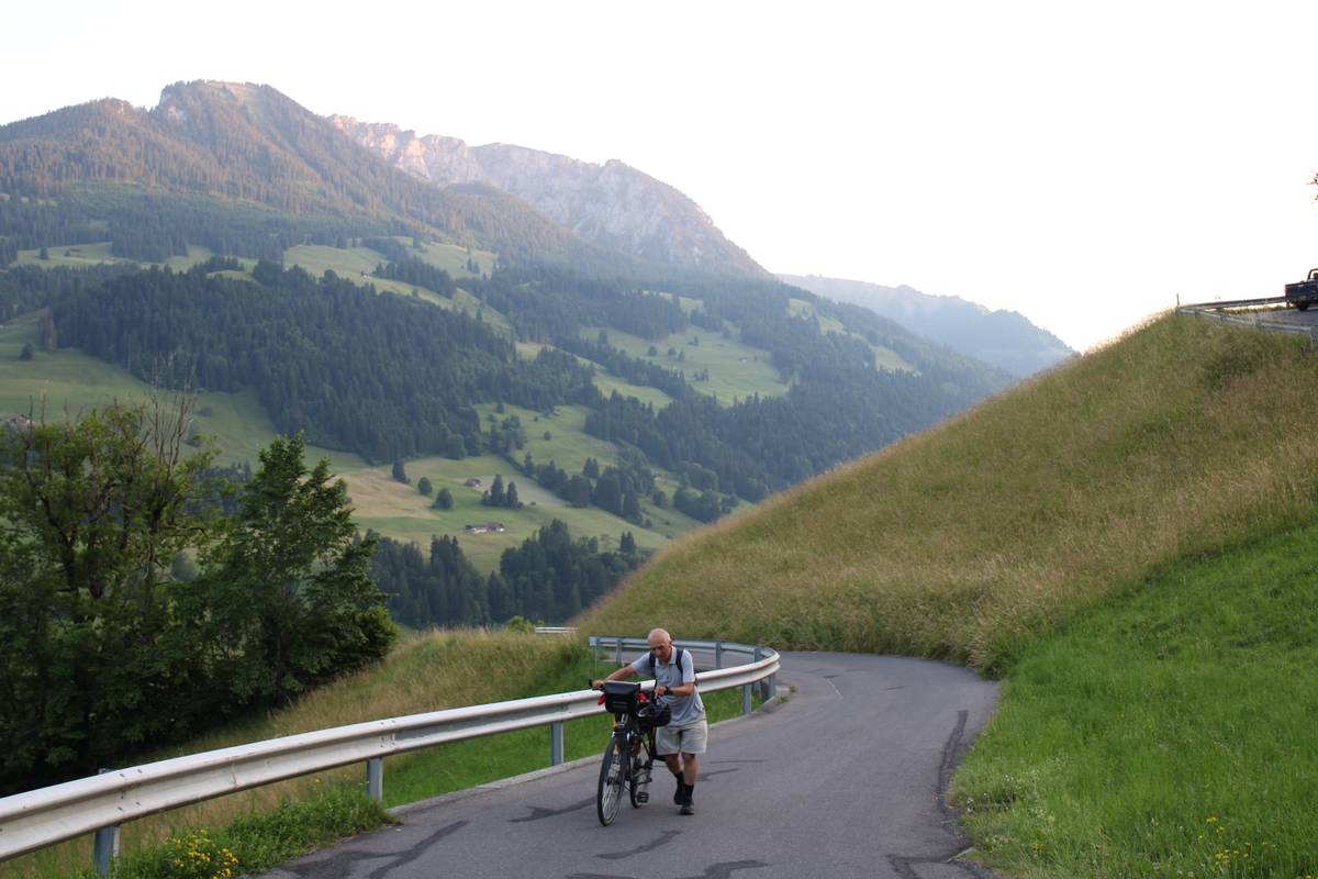 My dad pushes his loaded bike up the hill
